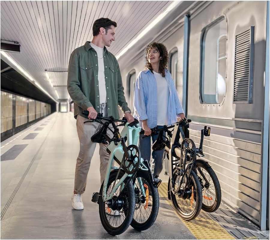 Pareja combinando bicicleta eléctrica plegable con el tren en una estación de metro